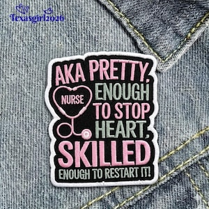 May include: A black and white patch with pink and green text. The patch reads "AKA PRETTY, NURSE, ENOUGH TO STOP HEART, SKILLED, ENOUGH TO RESTART IT!" A pink stethoscope is inside a heart shape. The patch is on a denim background.