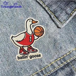 May include: Embroidered patch featuring a goose wearing a red basketball jersey with the number 1, holding a basketball. The patch has the words "ballin' goose" and is set against a denim background.