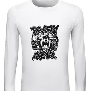Może przedstawiać: Biała koszulka z długim rękawem z czarną grafiką przedstawiającą postać Diabła Tasmańskiego i napisem "PARTY ANIMAL" w stylu graffiti. Projekt znajduje się na środku przodu koszulki.