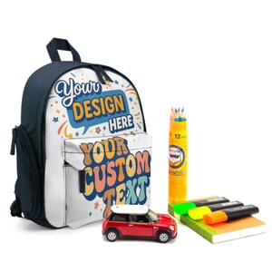 May include: A navy blue and white backpack with the text "Your Design Here" and "Your Custom Text". The backpack is next to a red toy car, a yellow pencil case, a notebook, and highlighters.