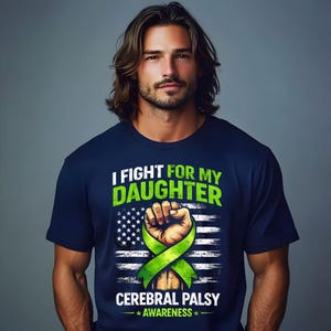 Op de afbeelding: Marineblauw t-shirt met de tekst "I FIGHT FOR MY DAUGHTER" in groen. Het ontwerp bevat een gebalde vuist, een groen lint en de woorden "CEREBRAL PALSY AWARENESS" met een Amerikaanse vlag achtergrond.