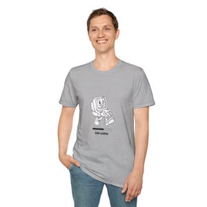 May include: A grey t-shirt with a cartoon computer character walking with a loading bar below. The text "Still Loading" is printed below the character. The t-shirt is being worn.