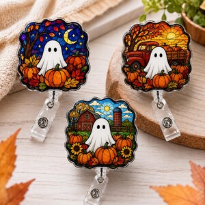 May include: Three badge reels featuring square scalloped frames with stained glass style illustrations. One shows a ghost with pumpkins and a crescent moon, another a ghost with a red truck and pumpkins, and the third a ghost with a barn and sunflowers.