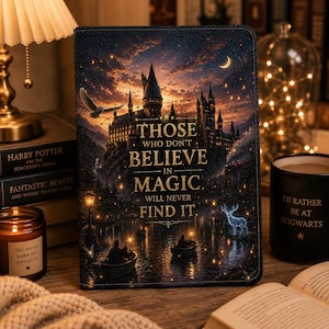 Peut inclure: Une couverture de livre sombre avec une illustration de château et le texte "Those Who Don't Believe in Magic Will Never Find It." L'image comprend une bougie, une tasse et d'autres livres.