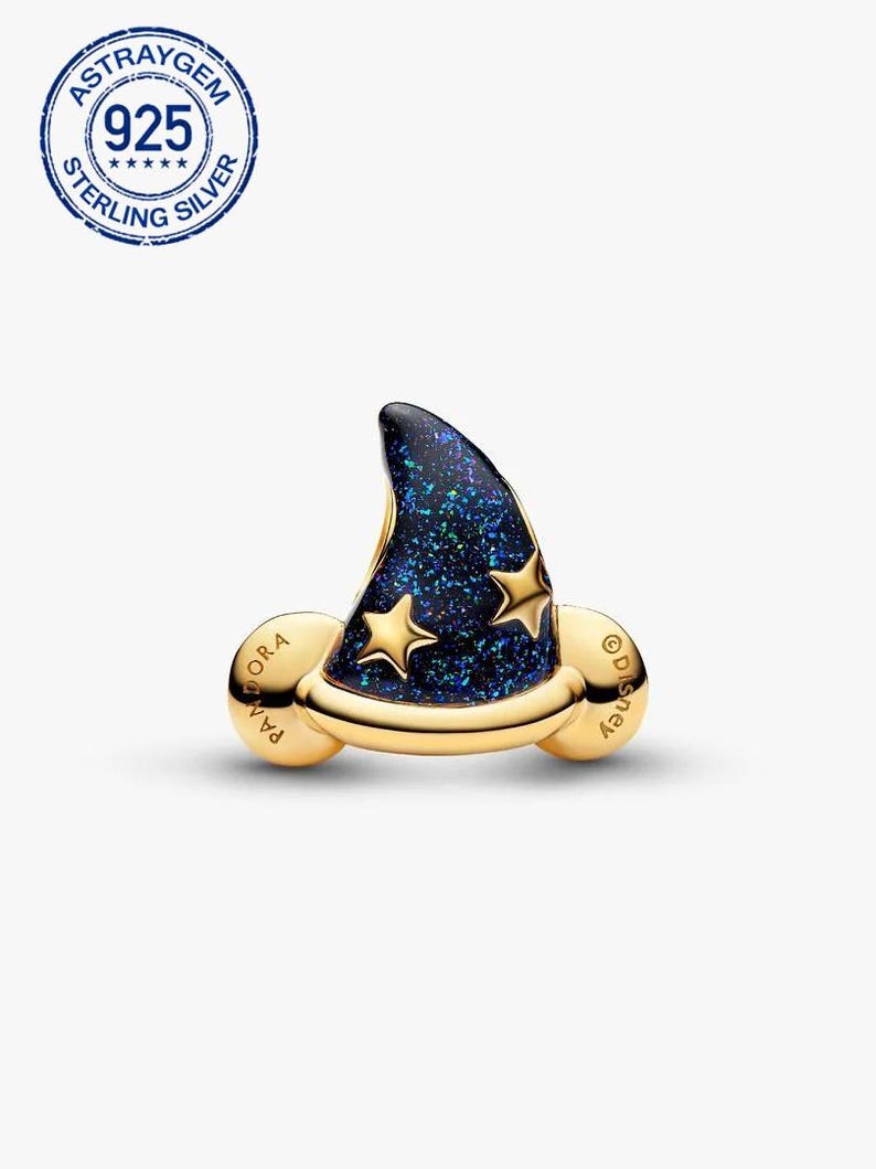 K&ouml;nnte beinhalten: Ein goldfarbener Charm-Anh&auml;nger mit einem Zaubererhut mit dunkelblauem, glitzerndem Finish und zwei goldenen Sternen. Der Charm hat das Wort "Pandora" auf der einen Seite und "Disney" auf der anderen Seite. Der Charm ist aus Sterlingsilber.