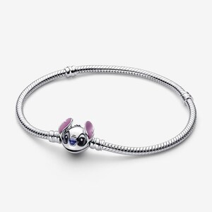 May include: A silver bracelet featuring a charm of the character Stitch from the Disney movie Lilo & Stitch. The charm is white with purple and pink accents. The bracelet has a snake chain design.