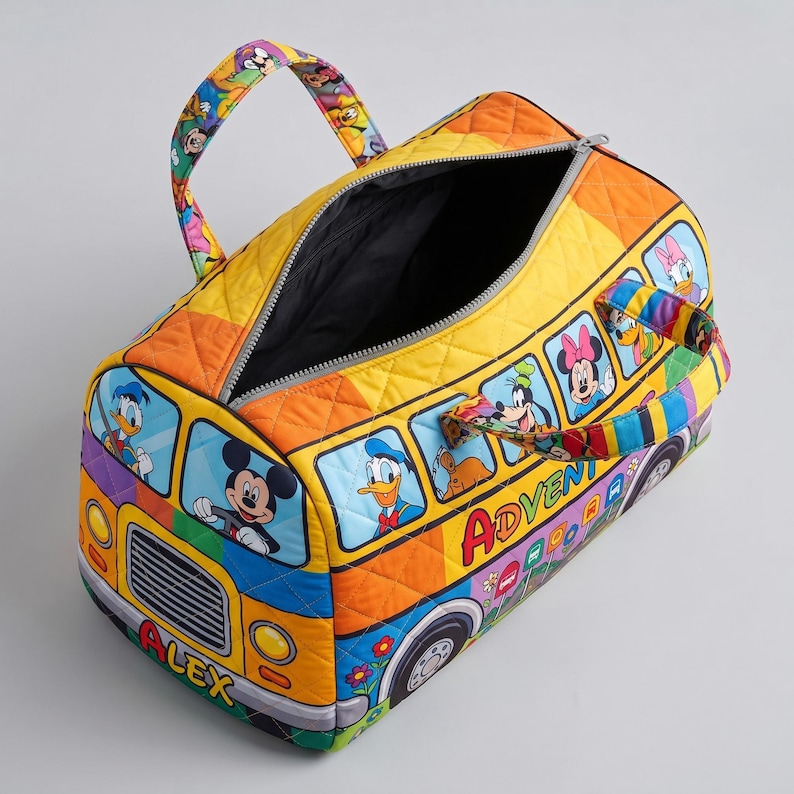 Puede incluir: Una colorida bolsa de lona acolchada con un dise&ntilde;o de autob&uacute;s y personajes de Disney. La bolsa tiene un esquema de color amarillo, naranja y azul, con cierre de cremallera y asas. La palabra "ADVENTURE" es visible en el lateral.