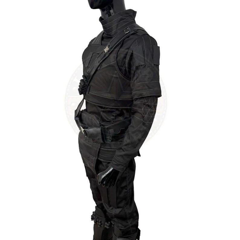 Pu&ograve; includere: Tuta tattica nera con collo alto, spalline e tasche multiple. L'outfit include un gilet, una cintura e guanti. Le maniche hanno cuciture geometriche. Il manichino &egrave; su sfondo bianco.