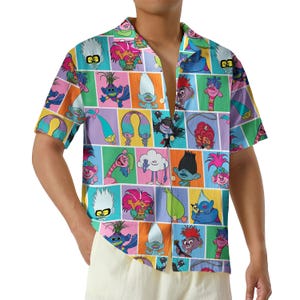 May include: Short-sleeved button-down shirt featuring a colorful pattern of cartoon characters in various poses. The shirt has a collared neckline and is made of a lightweight fabric. The design includes a variety of bright colors and geometric shapes.