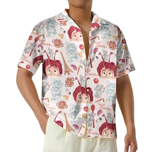 May include: White button-down shirt with a whimsical pattern featuring cartoon characters, the Eiffel Tower, and food items. The shirt has short sleeves and a relaxed fit. Text includes "Visit Paris" and "Your Only Limit Is Your Soul."