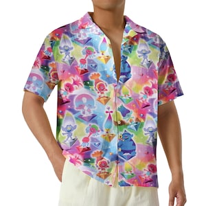 May include: A short-sleeved button-down shirt with a vibrant, colorful pattern featuring cartoon characters and geometric shapes. The shirt's design incorporates a rainbow of colors, including pink, blue, yellow, and green, creating a playful and eye-catching aesthetic.