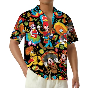May include: Short-sleeved button-down shirt with a black background and a colorful print featuring cartoon characters in festive attire. The design includes floral and decorative elements, creating a vibrant and playful aesthetic.