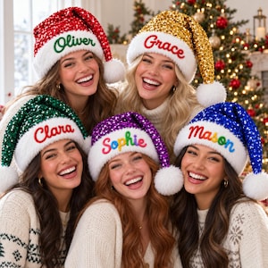 May include: Five sequined Santa hats in red, gold, green, purple, and blue, each featuring a white faux fur brim and a white pom-pom. The hats are embroidered with the names Oliver, Grace, Clara, Sophie, and Mason in colorful script.
