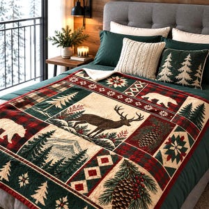 May include: A plush throw blanket featuring a patchwork design with images of a deer, bears, pine trees, pinecones, and geometric patterns in red, green, and cream. The blanket has a soft white sherpa lining and a red and green plaid border.