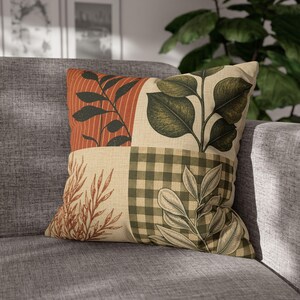 May include: A square throw pillow featuring a patchwork design with four distinct sections. The pattern includes dark green leaves on a rust-orange striped background, large green leaves on a cream base, brown botanical sketches, and green gingham.