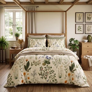 May include: A cream-colored duvet cover and two matching pillowcases featuring a botanical print of various green herbs, orange flowers, and small blue berries. The bedding set is displayed on a wooden bed frame with a beige throw blanket.