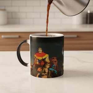 May include: A black and white ceramic mug featuring a colorful illustration of a group of animated characters. The mug is being filled with a dark liquid, likely coffee or tea, from a silver pitcher. The handle is black.