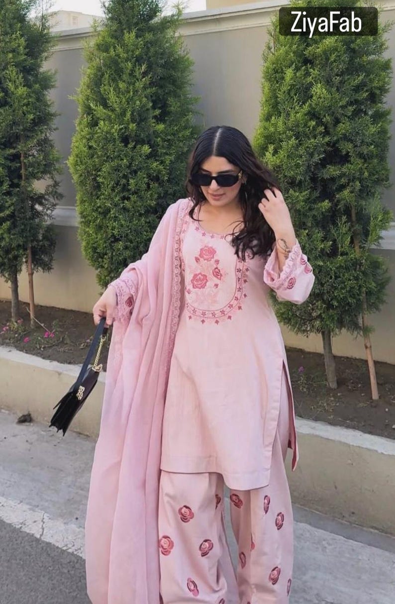 May include: A light pink embroidered salwar kameez set with matching palazzo pants and a dupatta. The top features floral embroidery around the neckline and on the sleeves. The palazzo pants have floral embroidery. The image includes the text "ZiyaFab".