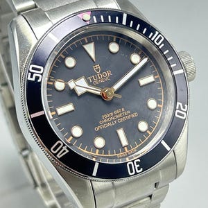 Relógio de pulso masculino Tudor Geneve com mostrador preto, movimento automático e pulseira de aço inoxidável (recondicionado).