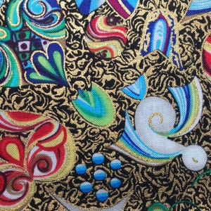 Könnte beinhalten: Nahaufnahme eines Stoffes mit schwarzem Hintergrund und goldenen Wirbeln. Bunte, stilisierte Formen in Rot, Blau, Grün und Gelb sind über den Stoff verstreut. Die Formen haben goldene Umrisse und Details, wodurch ein lebendiges und verziertes Design entsteht.
