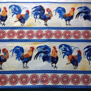 Könnte beinhalten: Stoff mit einem sich wiederholenden Muster aus blauen und orangefarbenen Hähnen auf weißem Grund. Die Hähne sind zwischen Reihen roter und weißer Kreisdesigns und blauen Bordüren angeordnet. Geeignet für Heimdekoration oder Bastelprojekte.