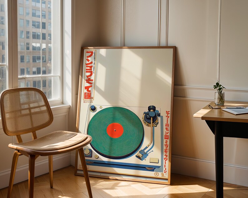 May include: A framed poster featuring a vintage turntable design. The artwork showcases a green vinyl record with a red center, a blue tone arm, and Japanese text. The poster is leaning against a wall next to a wooden chair.