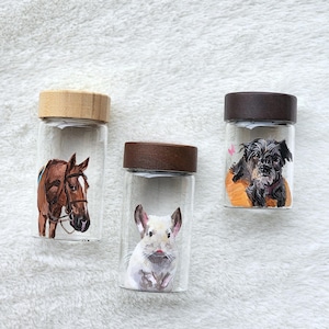 Hand-painted pet memorial jar with realistic portrait on UV-resistant glass, featuring an airtight seal for storing fur or ashes.