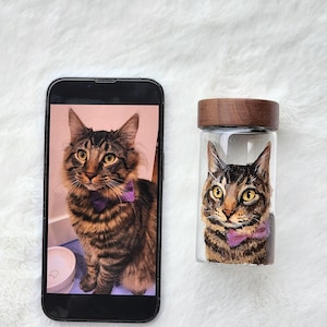 Hand-painted pet memorial jar with realistic portrait on UV-resistant glass, featuring an airtight seal for storing fur or ashes.
