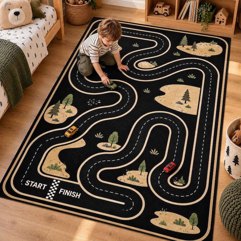 Puede incluir: Una alfombra rectangular negra con un patr&oacute;n de carretera sinuosa y marcas de carril blancas discontinuas. El dise&ntilde;o incluye parches de paisaje beige con &aacute;rboles y arbustos verdes. El texto START y FINISH est&aacute; impreso en blanco.