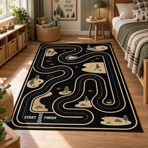 Puede incluir: Una alfombra rectangular negra con un patr&oacute;n de carretera blanca sinuosa y una l&iacute;nea de salida y meta a cuadros. El dise&ntilde;o incluye islas de color beige con &aacute;rboles y arbustos verdes dispersos por todo el trazado de la pista.