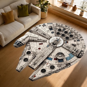 Puede incluir: Una alfombra redonda con un diseño detallado de la nave espacial Halcón Milenario de Star Wars. La alfombra es principalmente blanca con detalles grises, azules y rojos, colocada sobre un suelo de madera.