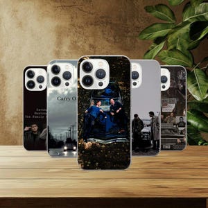 Może przedstawiać: Kolekcja pięciu etui na telefon z różnymi wzorami. Jedno etui zawiera tekst "Saving Hunting The Family". Inne wyświetla tekst "Carry O". Pozostałe etui mają zdjęcia ludzi i samochodów. Na drewnianej powierzchni.