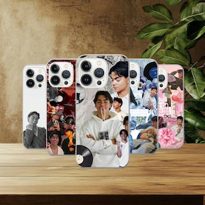 May include: Five phone cases with diverse designs. The cases showcase images of a young man, accompanied by graphics such as records, a disco ball, and floral patterns. The cases are presented on a wooden surface.