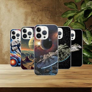 May include: Five phone cases with space-themed designs featuring spaceships and planets. The cases showcase vibrant colours, including blues, oranges, and blacks, with detailed illustrations of celestial bodies and spacecraft. The cases are displayed on a wooden surface.