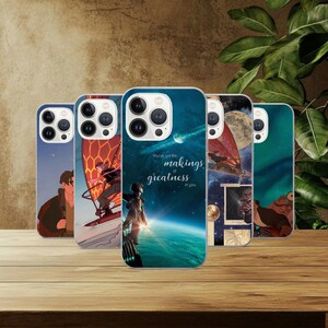 May include: A collection of phone cases with various designs. One case features a person standing with the text "You've got the makings of greatness in you." Other cases display illustrations of a person windsurfing, a full moon, and a cartoon character.