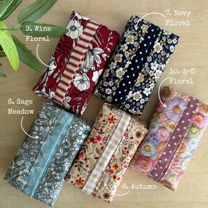 May include: Five rectangular fabric tissue holders featuring distinct patterns: 9. Wine Floral, 7. Navy Floral, 6. Sage Meadow, 8. Autumn, and 10. 3-D Floral. Each holder has a central vertical strip of contrasting fabric and a floral print.