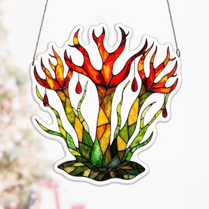 May include: Stained glass art piece depicting a stylized tree with red, orange, yellow, and green hues. The tree has a unique shape with a white outline and is suspended by a chain.