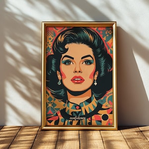Könnte beinhalten: Gerahmter Pop-Art-Druck mit einer Frau mit dunklem Haar und blauen Augen. Das Kunstwerk hat einen goldenen Rahmen und das Wort "confidence" steht unten. Die Frau trägt ein Oberteil mit geometrischem Muster.