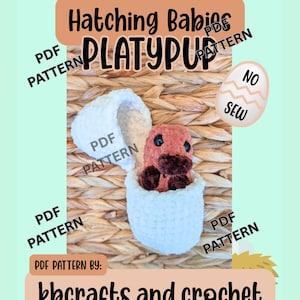 May include: A crochet pattern advertisement featuring a baby platypus emerging from a white crocheted egg. The text "Hatching Babies PLATYPUP" is displayed, along with "PDF PATTERN" and the website kbcrafts.and.crochet.