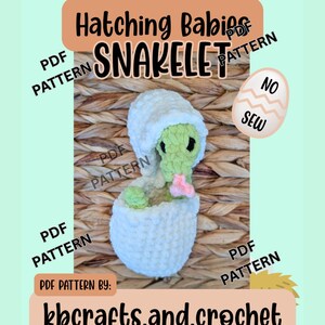 May include: A crochet pattern for a "Snakelet" baby hatching from an egg. The image features a green and white crocheted snake emerging from a white egg. Text includes "Hatching Babies Snakelet" and "kbcrafts.and.crochet".