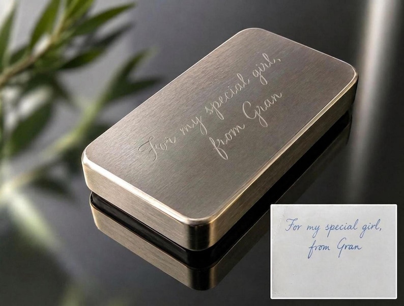 A solid brass plaque engraved with the cursive text For my special girl, from Gran sits on a dark reflective surface next to an inset image of the original handwritten note.