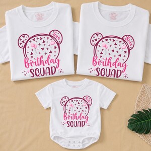 May include: Three white t-shirts and a onesie with matching designs. Each item features a pink bear-shaped graphic with the text "Birthday Squad". The bear design includes hearts, balloons, and the names "Lena", "Beau", and "Kate".