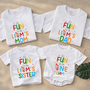 May include: White t-shirts and a onesie with colorful text and a baby's photo. The shirts read "It's FUN to be LIAM'S MOM", "It's FUN to be LIAM'S DAD", and "It's FUN to be LIAM'S SISTER". The onesie says "It's FUN to be ONE LIAM".