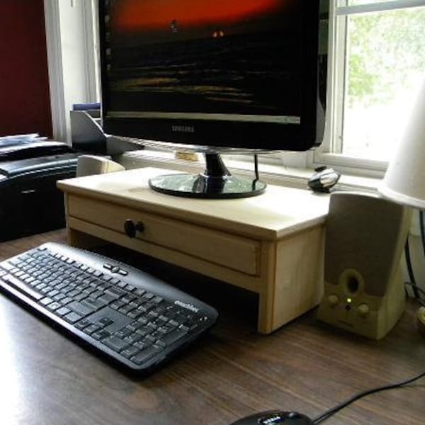 Computer monitor stand with drawer for extra storage and hidden hole in drawer back for cell phone chargers