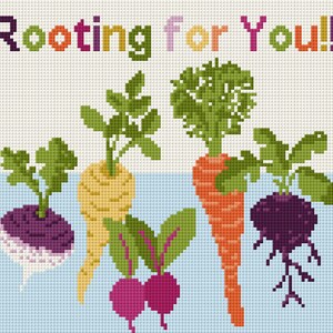 以下が含まれることがあります： 「Rooting for You!!!」の文字と、さまざまな根菜のイラストが描かれたクロスステッチのデザイン。野菜には、紫色のカブ、黄色のパースニップ、オレンジ色のニンジン、緑の葉が付いた赤いビーツが含まれています。