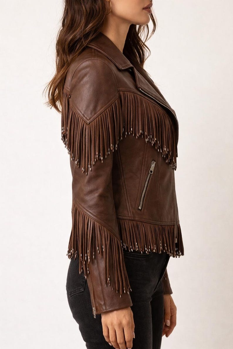 K&ouml;nnte beinhalten: Braune Lederjacke mit Fransen an Schultern und &Auml;rmeln. Die Jacke hat einen Rei&szlig;verschluss und ein klassisches Bikerjacken-Design. Ein stilvolles Oberbekleidungsst&uuml;ck.