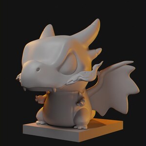 May include: A light gray dragon figurine with a large head, pointed ears, and small wings. The creature has a smooth, matte surface, visible fangs, and is positioned on a square base. The design features stylized, rounded proportions and a neutral tone.