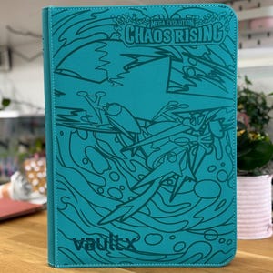 May include: A teal-coloured trading card binder featuring a textured surface with dark teal line art illustrations of water waves and abstract shapes. The text "MEGA EVOLUTION CHAOS RISING" is printed at the top, and the "vaultx" logo is at the bottom.