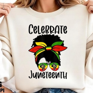 Może przedstawiać: Kremowa bluza z napisem "Celebrate Juneteenth" czarnym pismem. Grafika przedstawia sylwetkę kobiety z kolorową opaską na głowę i okularami przeciwsłonecznymi. Okulary przeciwsłoneczne mają grafikę pięści.