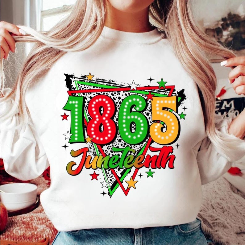 Może przedstawiać: Biała bluza z kolorowym wzorem graficznym. Projekt przedstawia liczby "1865" w kolorze czerwonym, zielonym i ż&oacute;łtym, z napisem "Juneteenth" poniżej. Projekt zawiera gwiazdy i czarno-białe cętkowane tło.